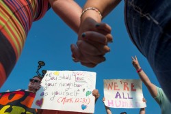 MOREHEAD, KY - SEPTEMBER 04: Same sex marriage supporters holds hands and hold up their signs during a protest in front of the Rowan County Courthouse September 4, 2015 in Morehead, Kentucky. Kim Davis, an Apostolic Christian and a Rowan County clerk, refused to issue marriage licenses to same sex couples in defiance of a Supreme Court ruling, citing religious objections. Davis was held in contempt of court and placed in Carter County jail on Thursday, September 3rd. (Photo by Ty Wright/Getty Images)